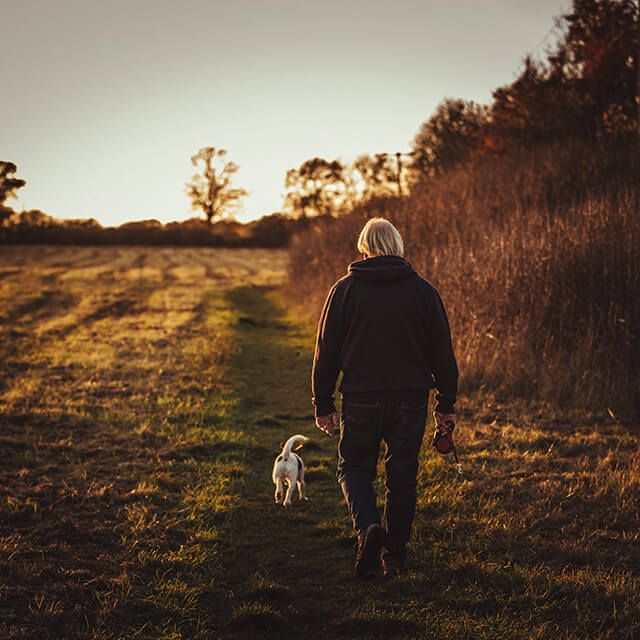person with blond hair walking their dog