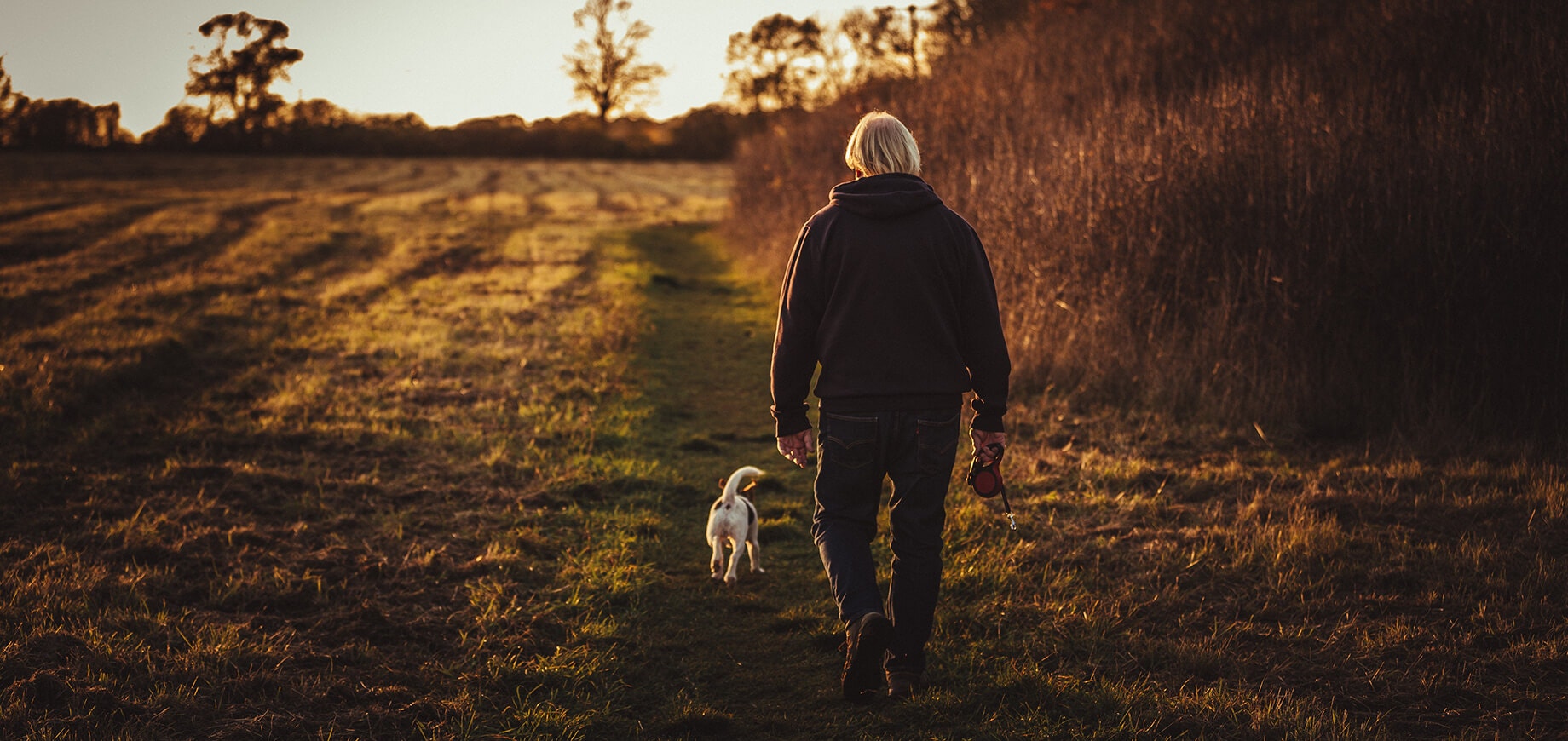 person with blond hair walking their dog